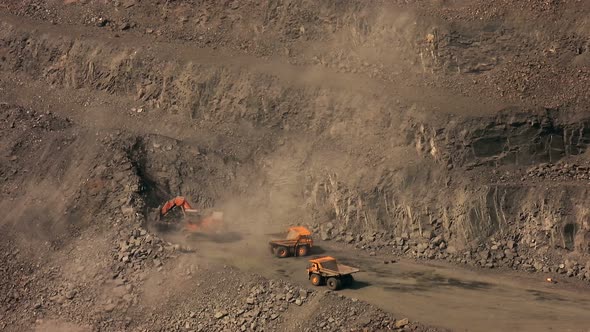 Yellow excavator shovels ore with a bucket in a quarry and pours it into a dump truck time lapse