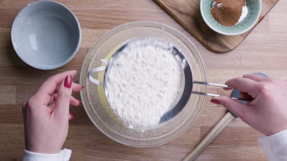 Baker Sifting Flour Through Fine Mesh Sieve For Cake Dough. - Top Down Shot alt