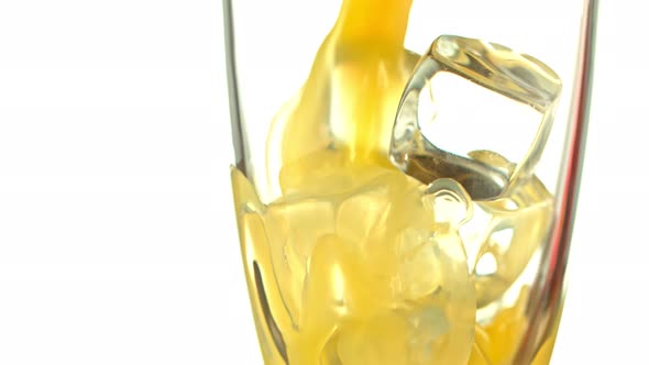 Super Slow Motion Shot of Pouring Fresh Orange Juice Into Glass with Ice Cubes at 1000 Fps alt