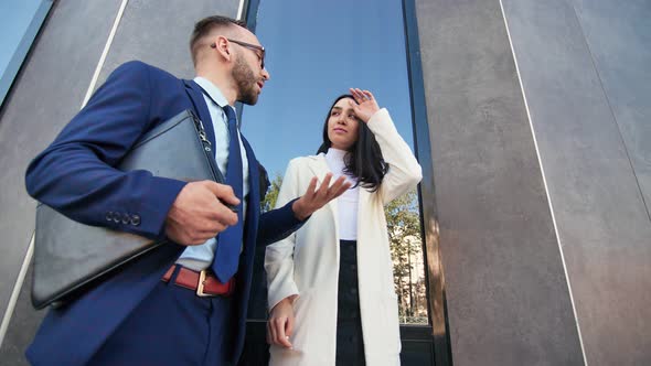 Male Boss and Female Employee Discussing Business Standing Outdoor alt