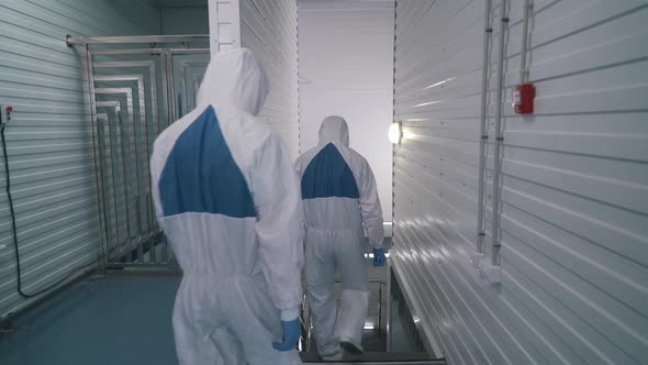 Workers in Protective Suits Go To Production