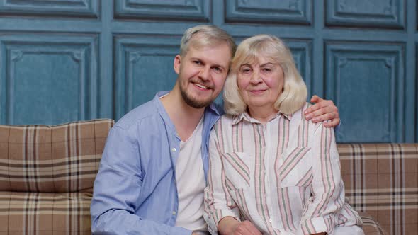 Family of Senior Mother and Handsome Adult Son or Grandson Looking at Camera Domestic Weekends alt
