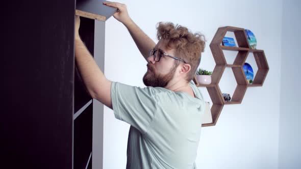 Bearded Man Assembling New Furniture at Home alt