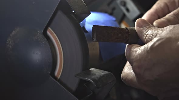 Close up from hand holding and sharpening rusty masonry chisel