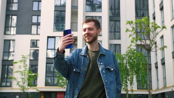 Young Man Using Mobile Phone for Video Call Outside alt