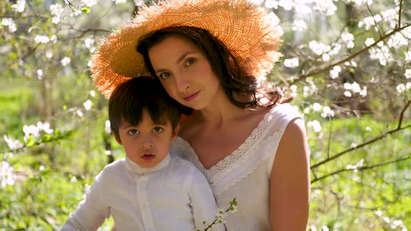 Mom in a Straw Hat Stands with Her Son alt