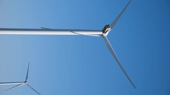 Working Twisting Windmills Stand in a Field in Summer alt