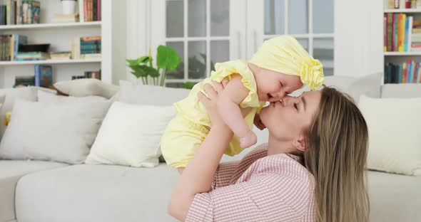 Young Beautiful Mother Blonde Holding a Newborn Baby in Her Arms Indoors alt