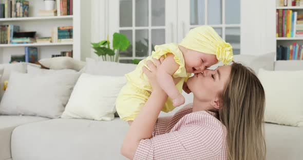Young Beautiful Mother Blonde Holding a Newborn Baby in Her Arms Indoors