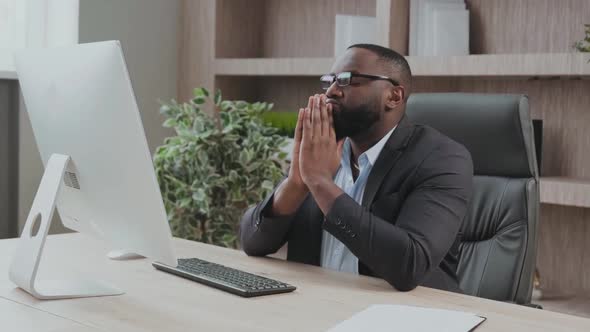 Young Business Professional Tries to Calm Down and Concentrate at His Office Desk in Front of the alt