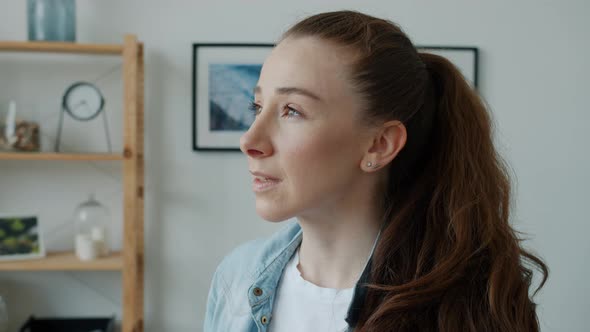 Beautiful Young Woman with Ponytail Turning to Camera and Smiling at Home alt