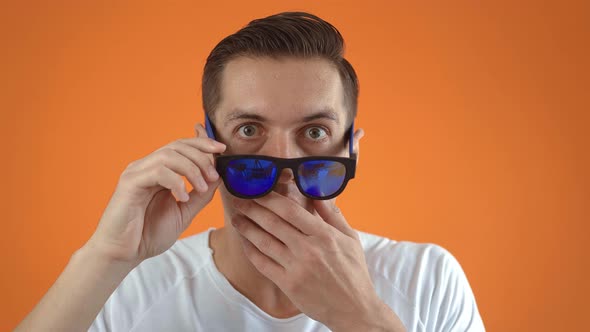 Stylish Young Man Shocked and Surprised on Orange Color Background alt
