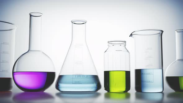 Laboratory glassware with colorful liquids inside on a light background looping.