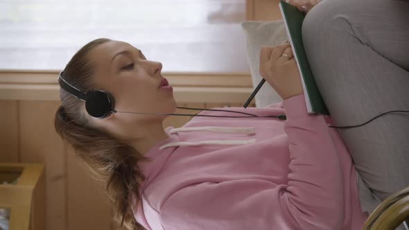 Vertical Shot Caucasian Girl in Headphones Taking Online Course on Internet in Selfisolation