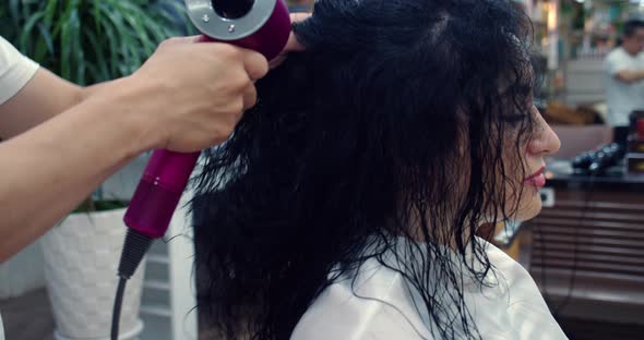 Brunette Woman in a Beauty Salon Has Haircut in a Barbershopin a Barbershop a Man Does a Hairstyle alt