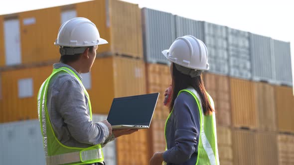 Two logistic staff checking and control loading containers box from cargo