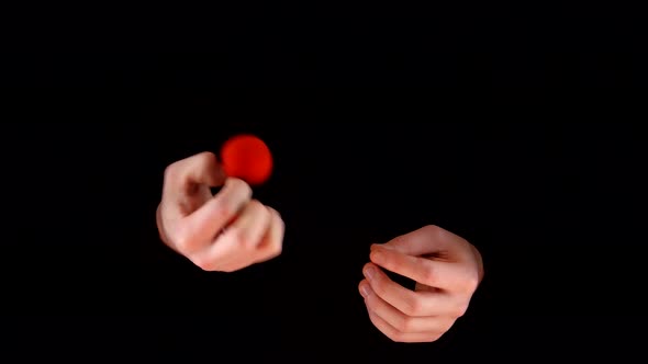 Magician Making Trick with Red Balls on Black Background alt