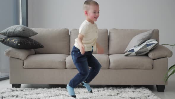 Happy Little happy boy jumps on carpet in livingroom