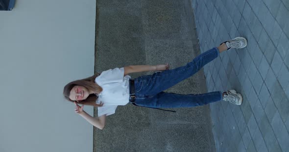 Cheerful Female Teen Dancing Solo Front Camera in Stylish Look on Background alt