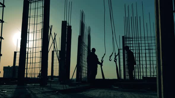 Workers Install Carcass Mesh on a Roof. alt