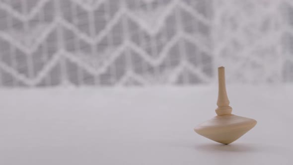 Human Hand in Black Vinyl Glove is Launching Wooden Spinning Top alt