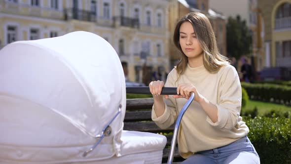 Exhausted Mom Feeling Sleepy Swinging Baby Stroller in Park, Parenthood Crisis alt
