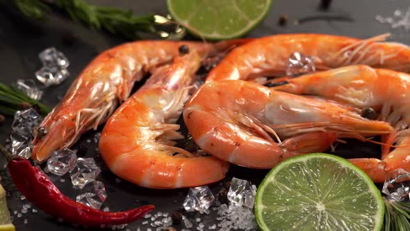 Raw Orange Prawns in Ice with Lemon Chili and Rosemary on Stone Cutting Board