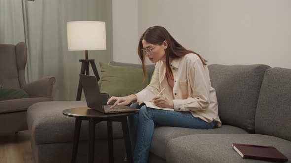 A European Student Writes in a Notebook and Types at the Same Time alt