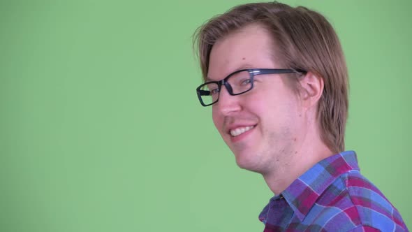 Closeup Profile View of Happy Young Hipster Man Looking at Camera alt