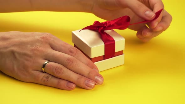 Woman Opens a Small Box with a Gift