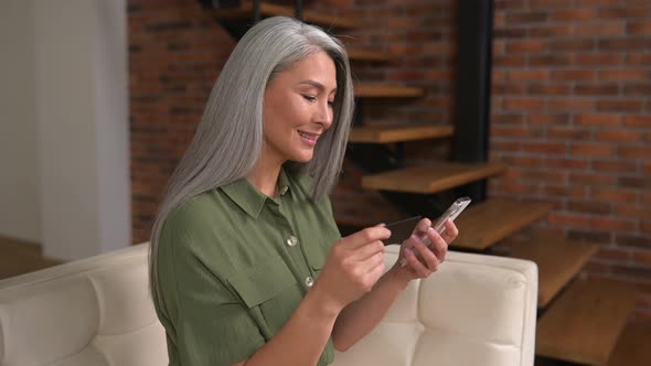 Multiracial Grayhaired Lady Using Mobile for Shopping Online