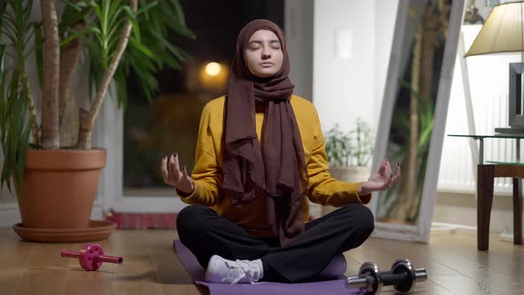 Wide Shot of Confident Middle Eastern Woman Meditating in Lotus Pose with Closed Eyes alt