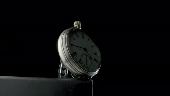 Silver Antique Pocket Watch on a Stand Rotating on a Black Isolated Background alt