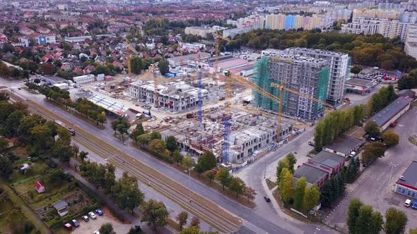 Construction of a residential building. Drone footage of construction site and cranes. Orbit shot. G alt