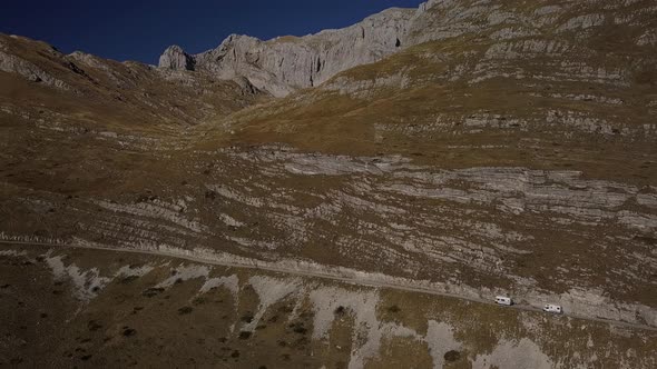 Camper Cars Driving Along Road on Background of Amazing Rocks on Autumn Day Rbbro alt