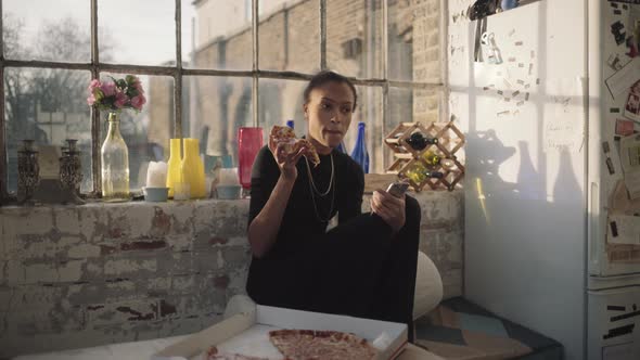 Young adult woman eating Pizza at home