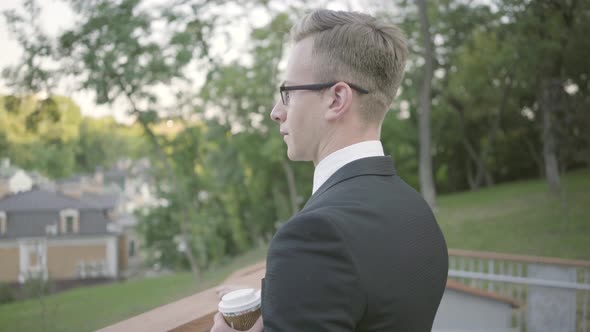 Successful Businessman Standing on the Terrace with Coffee alt