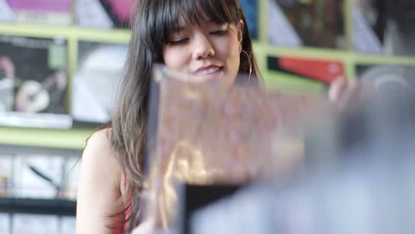 A Young Woman eagerly browses through a selection of vintage records