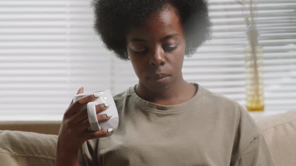Afro-American Woman Drinking Tea and Using Laptop at Home alt