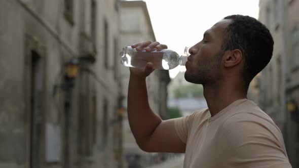 Side View of the Man Runner Drinking Water After the Scamper alt