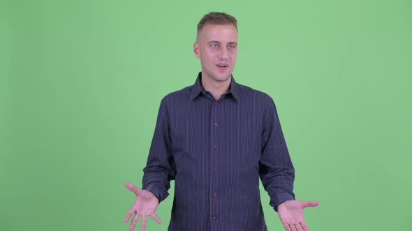 Happy Handsome Businessman Looking Around and Feeling Excited alt