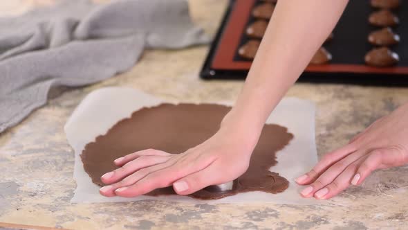 Woman Cutting Chocolate Shortcrust Dough Into Circles, Making Choux Buns with Craquelin alt
