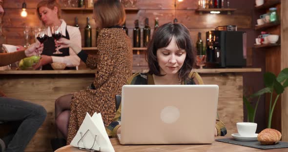 Young Female Designer Works on Her Project in a Coffee Shop alt