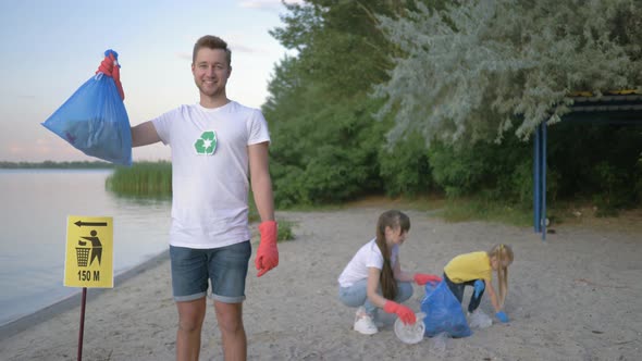 Environmental Protection, Portrait of Happy Volunteer Male in Rubber Gloves with Garbage Bag Near alt