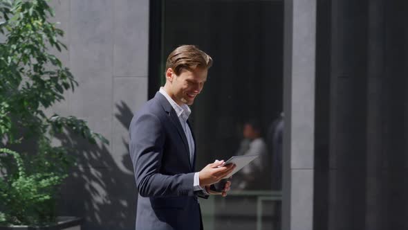 Smiling Finance Worker Checking Smartphone Walking in Modern Workplace Outside alt