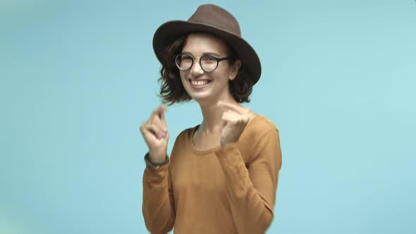 Attractive Girl Tourist in Glasses and Fancy Hat Pointing Fingers at Camera Smiling and Choosing you