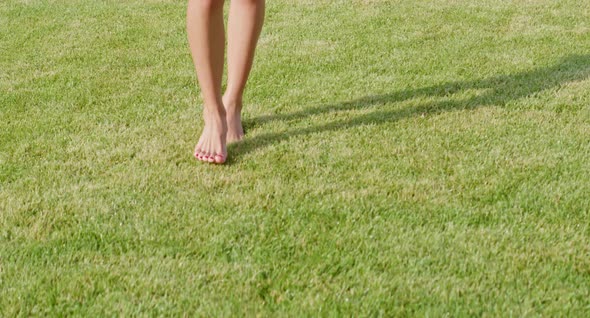 Close Up of Woman Walking on Lawn with Barefoot alt