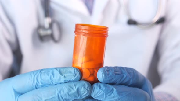 Doctor Hand in Protective Glass Holding Pill Container  alt