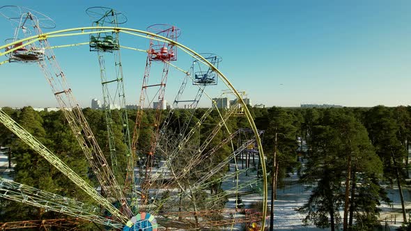 Flying Next to an Empty Old Ferris Wheel in a Winter Park