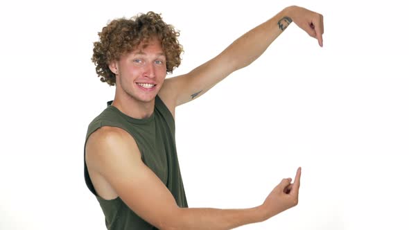 Caucasian Curly Cheerful Guy with Green Eyes Looking on Camera Demonstrating Something Good Showing alt